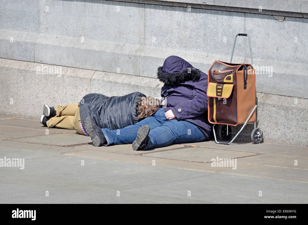 Londra, Inghilterra, Regno Unito. Due persone che dormono in Trafalgar Square nel centro del giorno Foto Stock