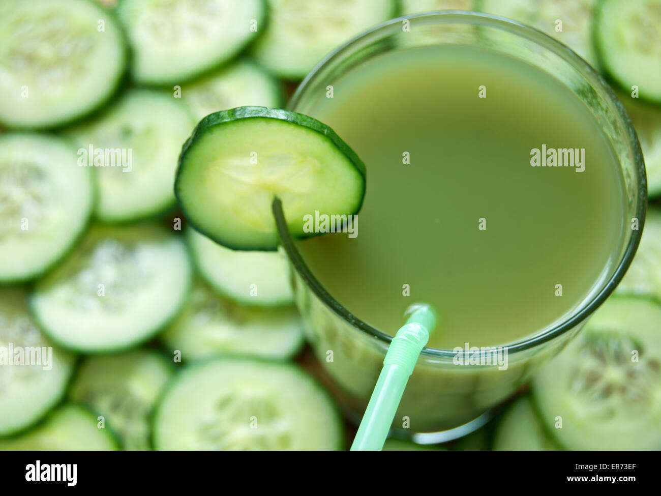 Fresche e vegetali detox succo con fette di cetriolo in background Foto Stock