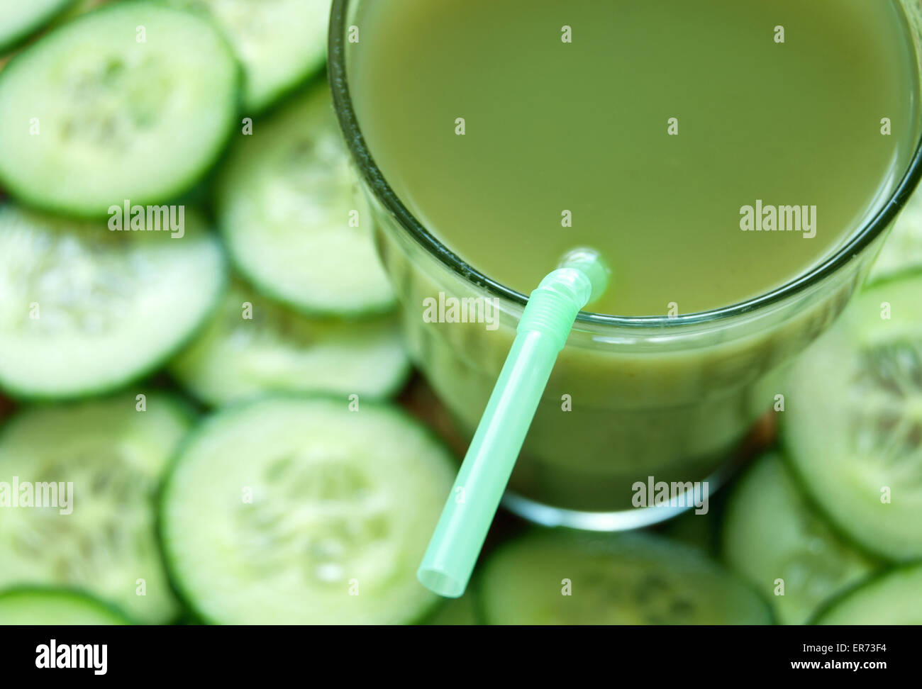 Fresche e vegetali detox succo con fette di cetriolo in background Foto Stock