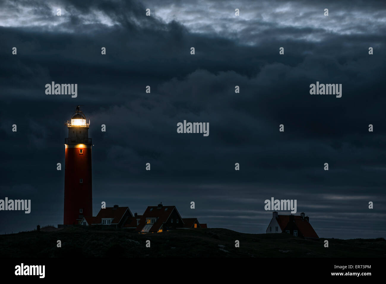 Eierland faro con la luce della lanterna lucenti oltre mare di Wadden durante la notte su isola olandese di Texel, Isole Frisone, Paesi Bassi Foto Stock
