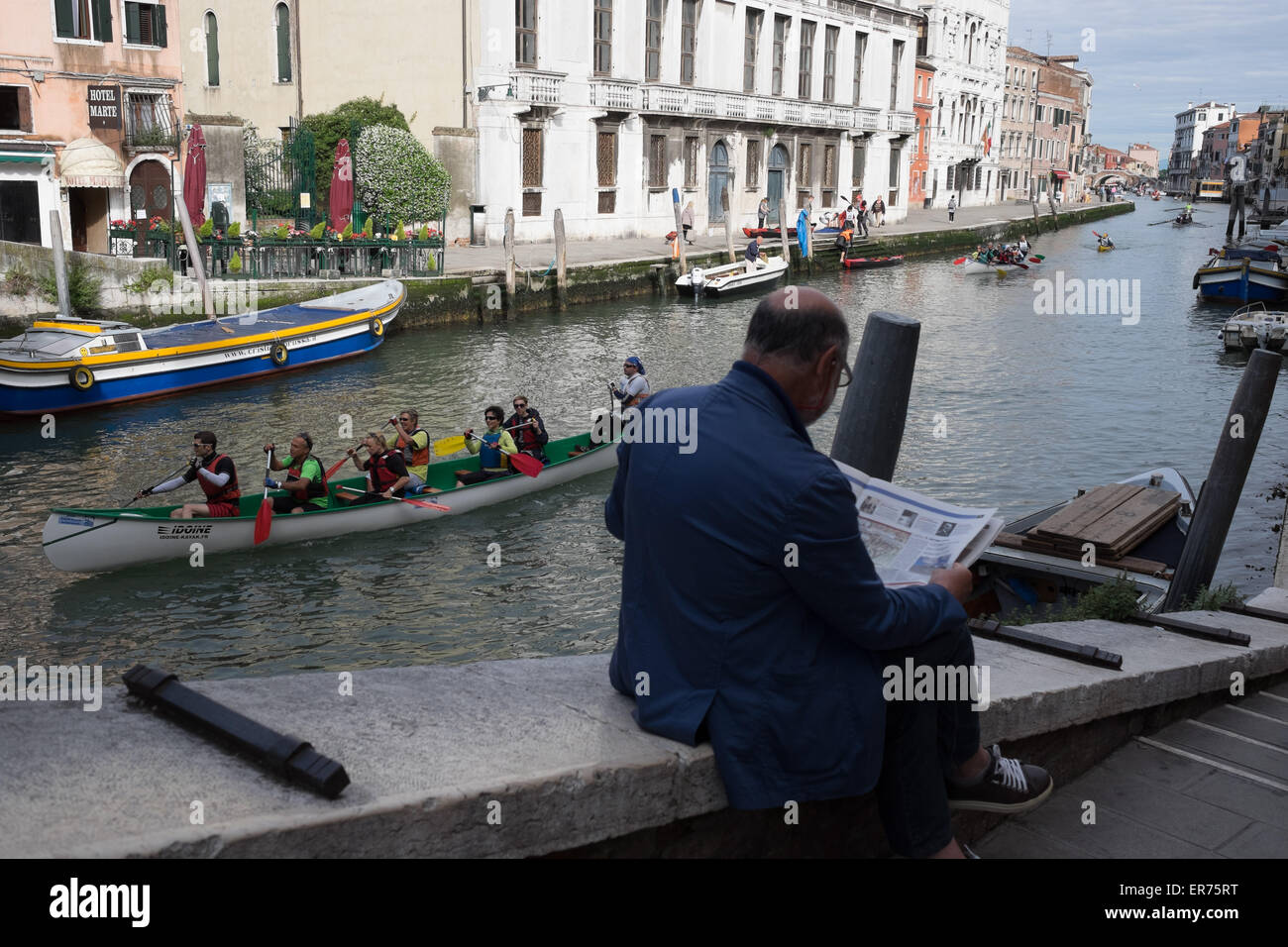 Il Volgalonga, annuale gara di canottaggio a Venezia in Italia. Quarantunesima Volgalonga annuale. Uomo che legge il giornale in Venezia Italia. Foto Stock