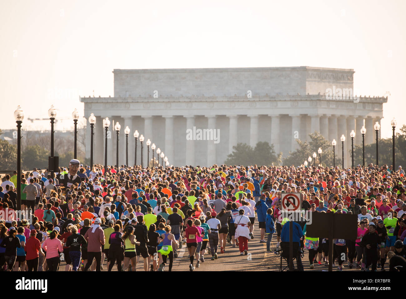 WASHINGTON DC, Stati Uniti - i corridori gareggiano nell'annuale Cherry Blossom Ten Mile Run mentre attraversano l'Arlington Memorial Bridge con il Lincoln Memorial visibile sullo sfondo. La gara primaverile, che coincide con il National Cherry Blossom Festival, attira migliaia di partecipanti nella capitale della nazione. Foto Stock