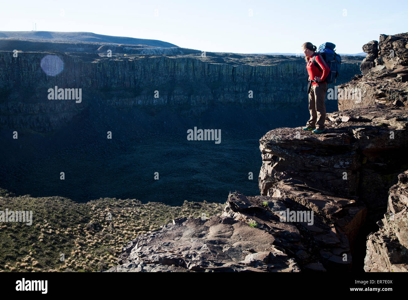 Una donna che indossa uno zaino si erge al di sopra del francese Coulee, Washington. Foto Stock