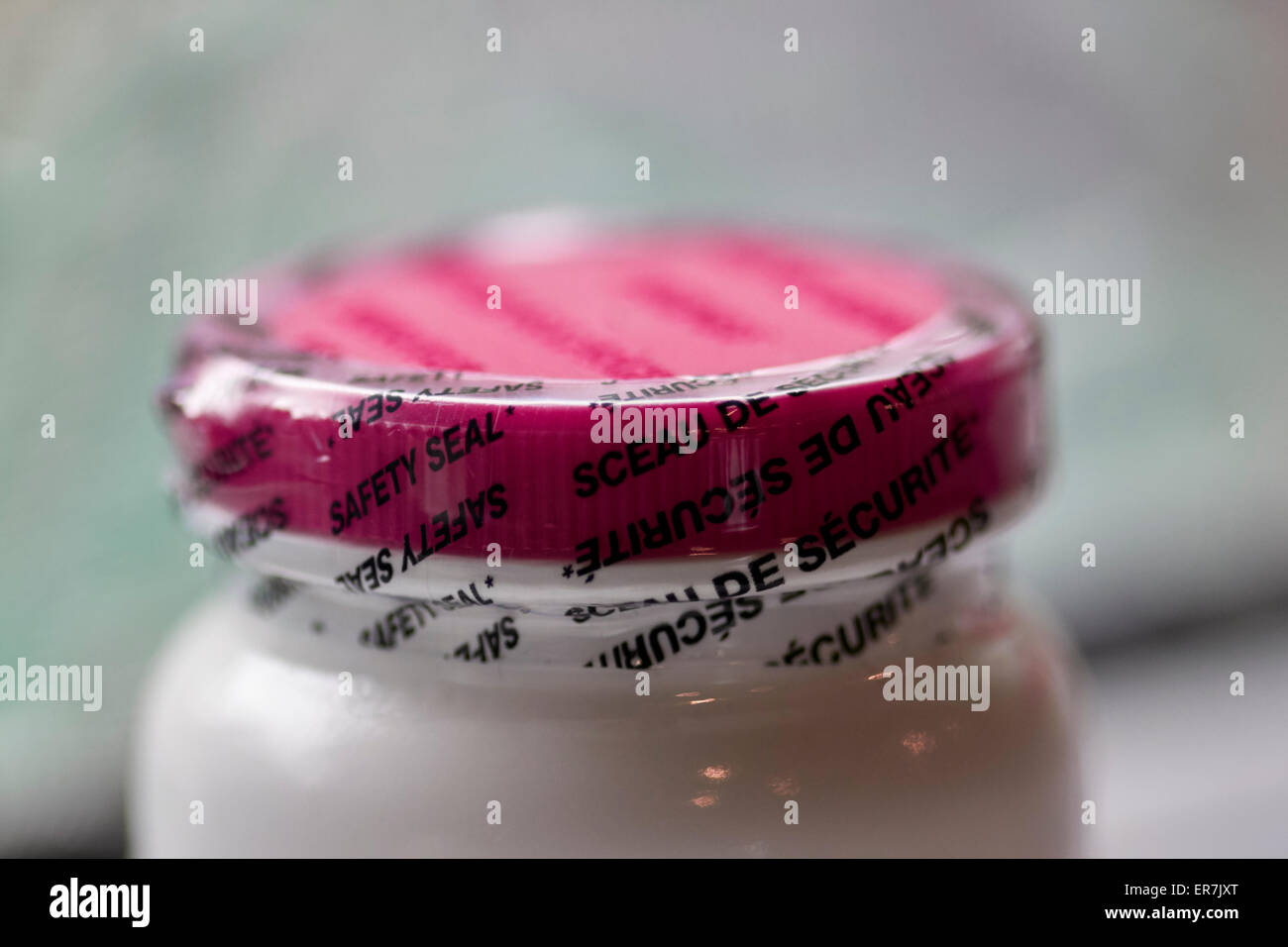 La protezione in plastica la guarnizione sul coperchio a prova di manomissione sulla parte superiore di una bottiglia di pillole Foto Stock