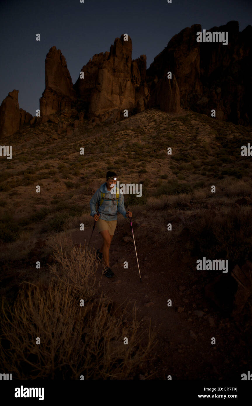 Donna escursioni a piedi di notte da proiettore sul tesoro Loop Trail in Lost Dutchman State Park vicino a Phoenix, Arizona, novembre 2011. Foto Stock