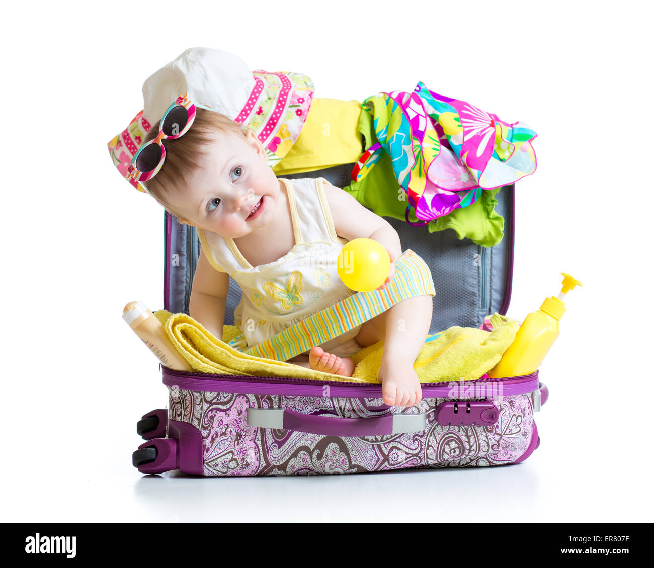 Baby ragazza seduta in valigia con le cose per vacanze viaggi isolato Foto Stock