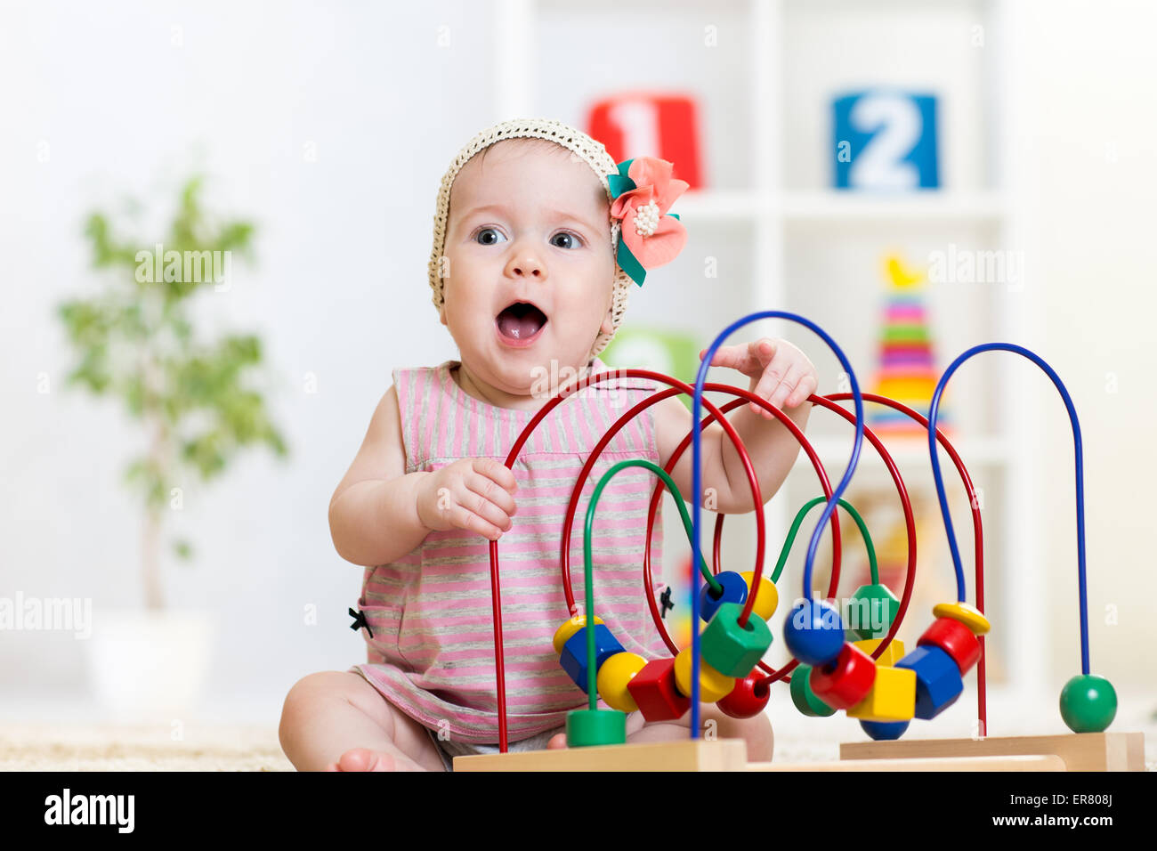 Kid bambina gioca con il giocattolo educativo in ambienti interni Foto Stock