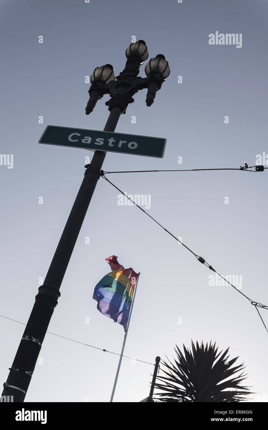 Basso angolo vista di Castro strada segno e bandiera arcobaleno contro il cielo chiaro Foto Stock