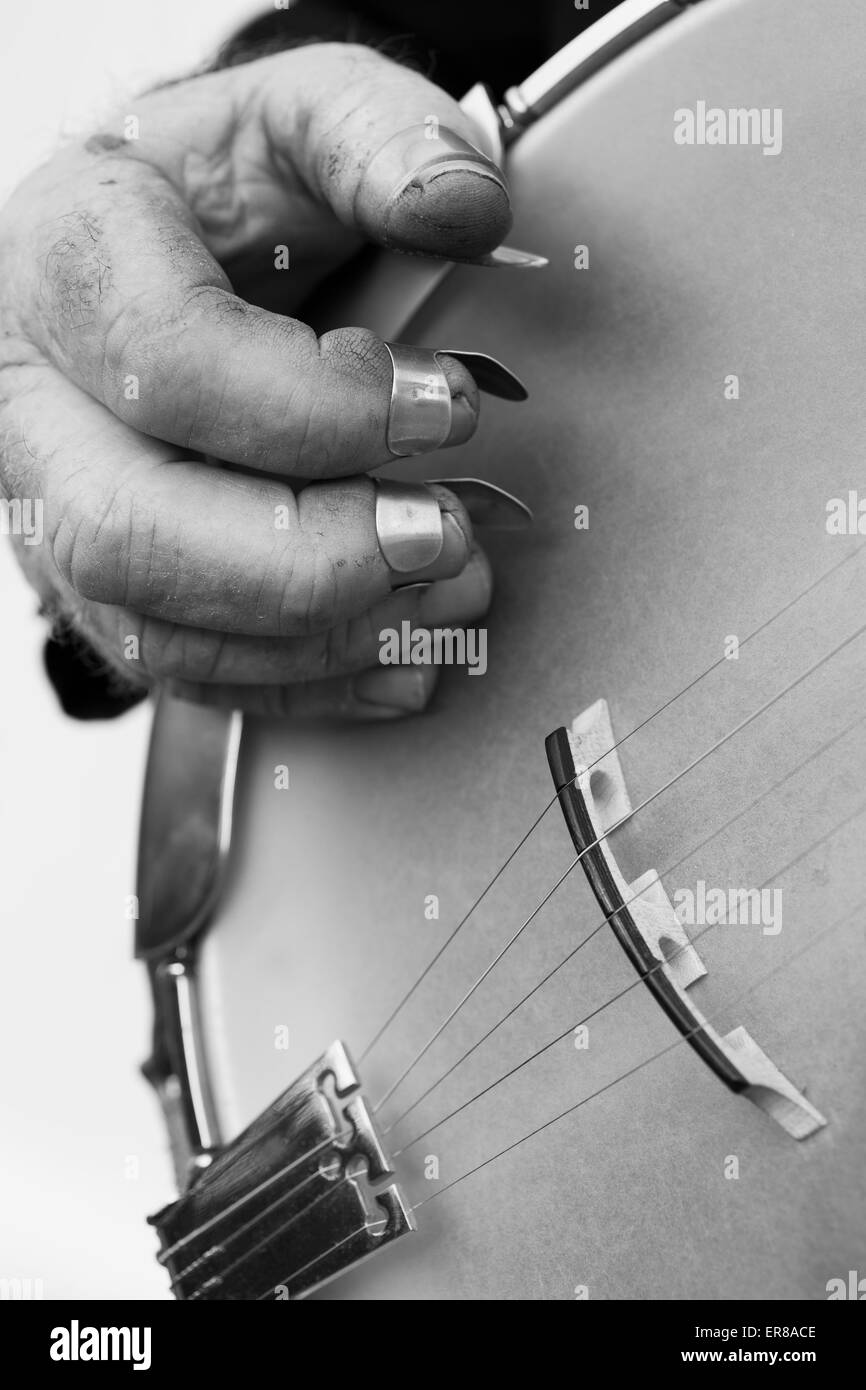 Immagine ritagliata di mano la riproduzione di strumento a corda contro uno sfondo grigio Foto Stock