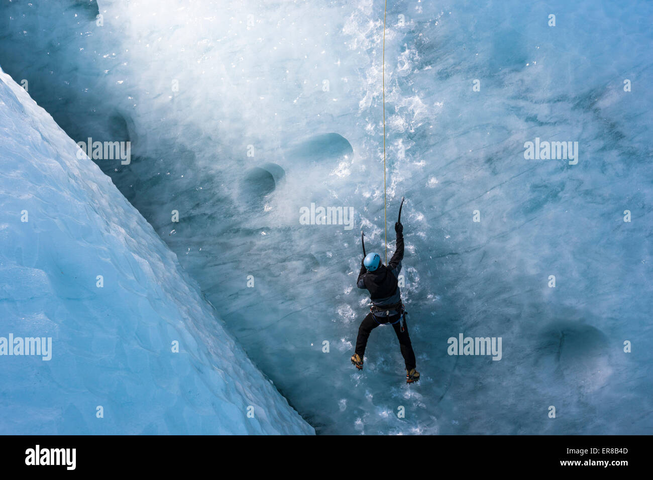 Uomo di arrampicata ghiacciaio verticale Parete di ghiaccio Foto Stock