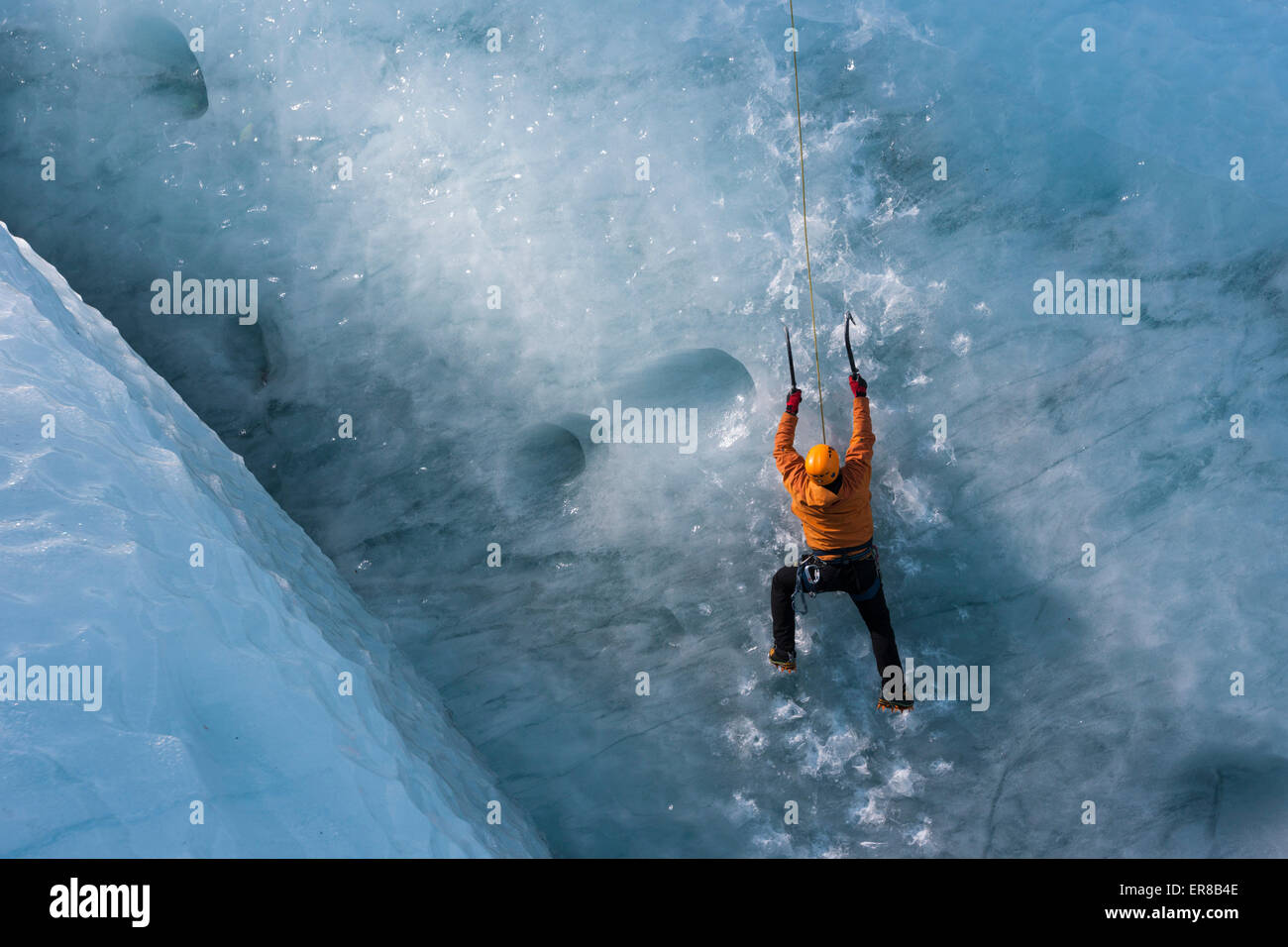 Uomo di arrampicata ghiacciaio verticale Parete di ghiaccio Foto Stock