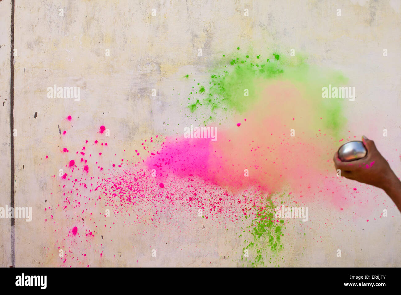 Immagine ritagliata di mano gettando le vernici in polvere sulla parete durante Holi Foto Stock