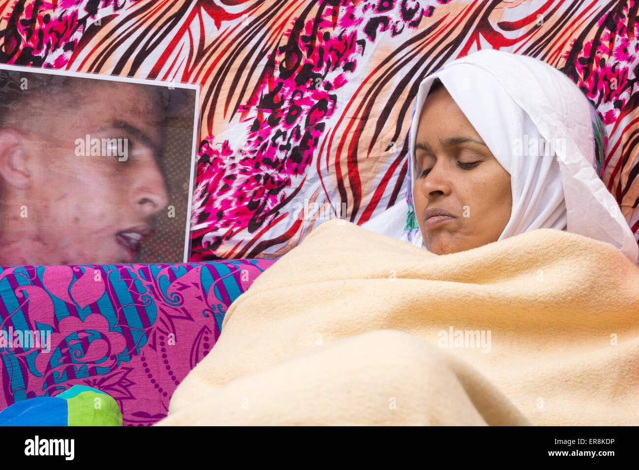 Isole Canarie, Spagna. 29 Maggio, 2015. Haddi Takbar dal Sahara Occidentale inizia il suo quindicesimo giorno di un indefinate sciopero della fame su un divano al di fuori del consolato marocchino a Las Palmas, circondato da foto di suo figlio morto, che esigono un'indagine sulla morte del suo 21 enne figlio Mohamed Lamin Haidala, che ella sostiene era "urdered dai coloni Moroccon' in El Aauin, la più grande città del contestato il territorio del Sahara Occidentale, nel febbraio 2015. Credito: ALANDAWSONPHOTOGRAPHY/Alamy Live News Foto Stock