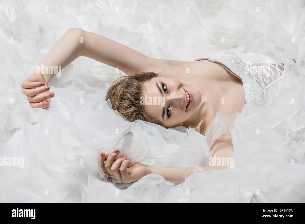 Ritratto di sorridente giovane sposa in abito da sposa sdraiato Foto Stock
