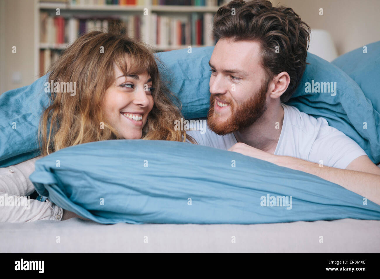 Amorevole coppia giovane guardando ogni altro mentre giaceva a letto Foto Stock