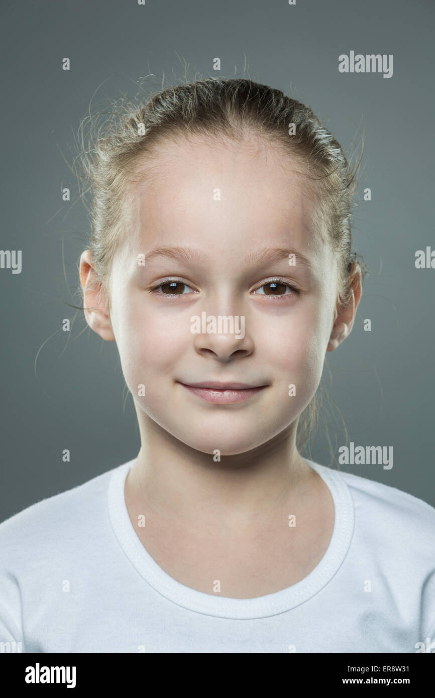 Close-up ritratto della ragazza carina contro uno sfondo grigio Foto Stock