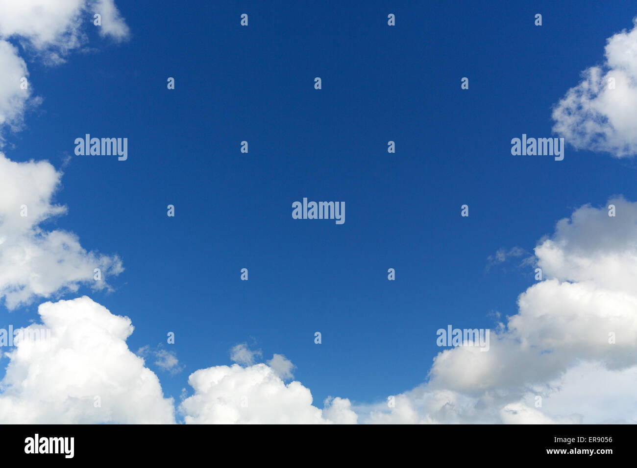Blue Sky copia spazio circondato da una cornice di bianco soffice nuvola. Random nuvole naturali formando uno spazio circolare per un messaggio Foto Stock