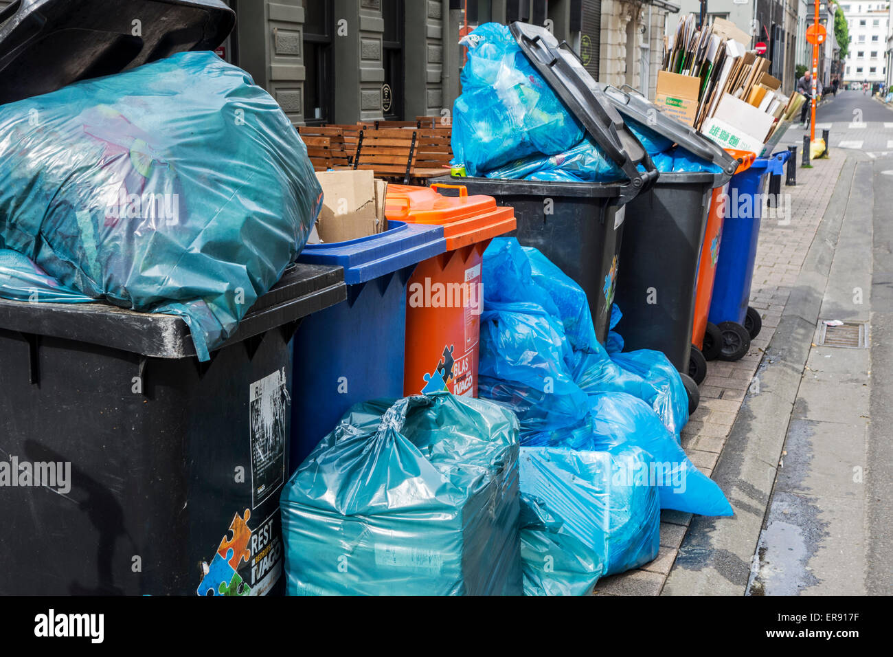 Sacchi per immondizia e contenitori per rifiuti con ammucchiati rifiuti domestici di pavimentazione di bloccaggio a causa dello sciopero dei rifiuti impresa di trasformazione Foto Stock