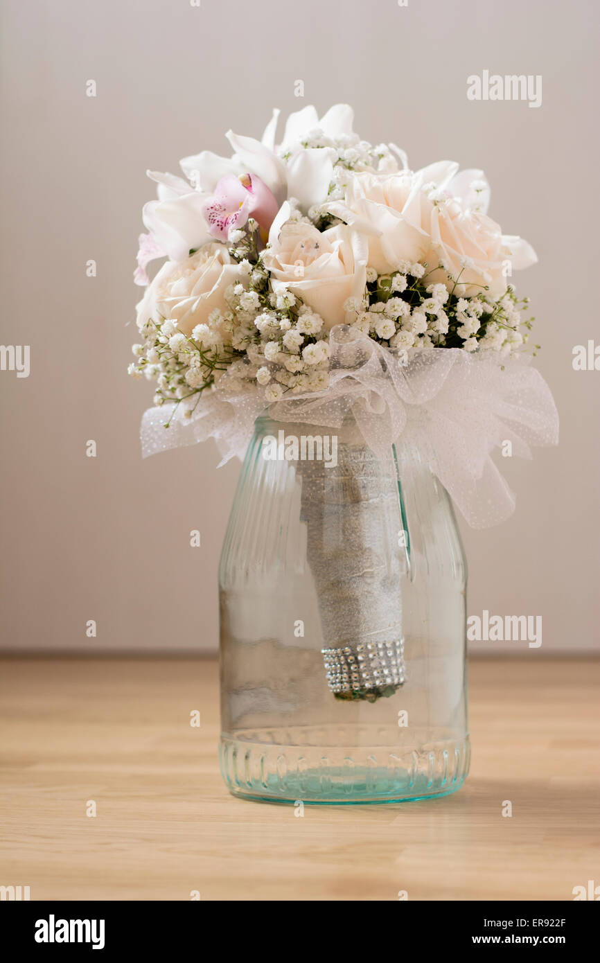 Bouquet nozze con rose bianche e orchidee in tazza di vetro indoor sul pavimento Foto Stock