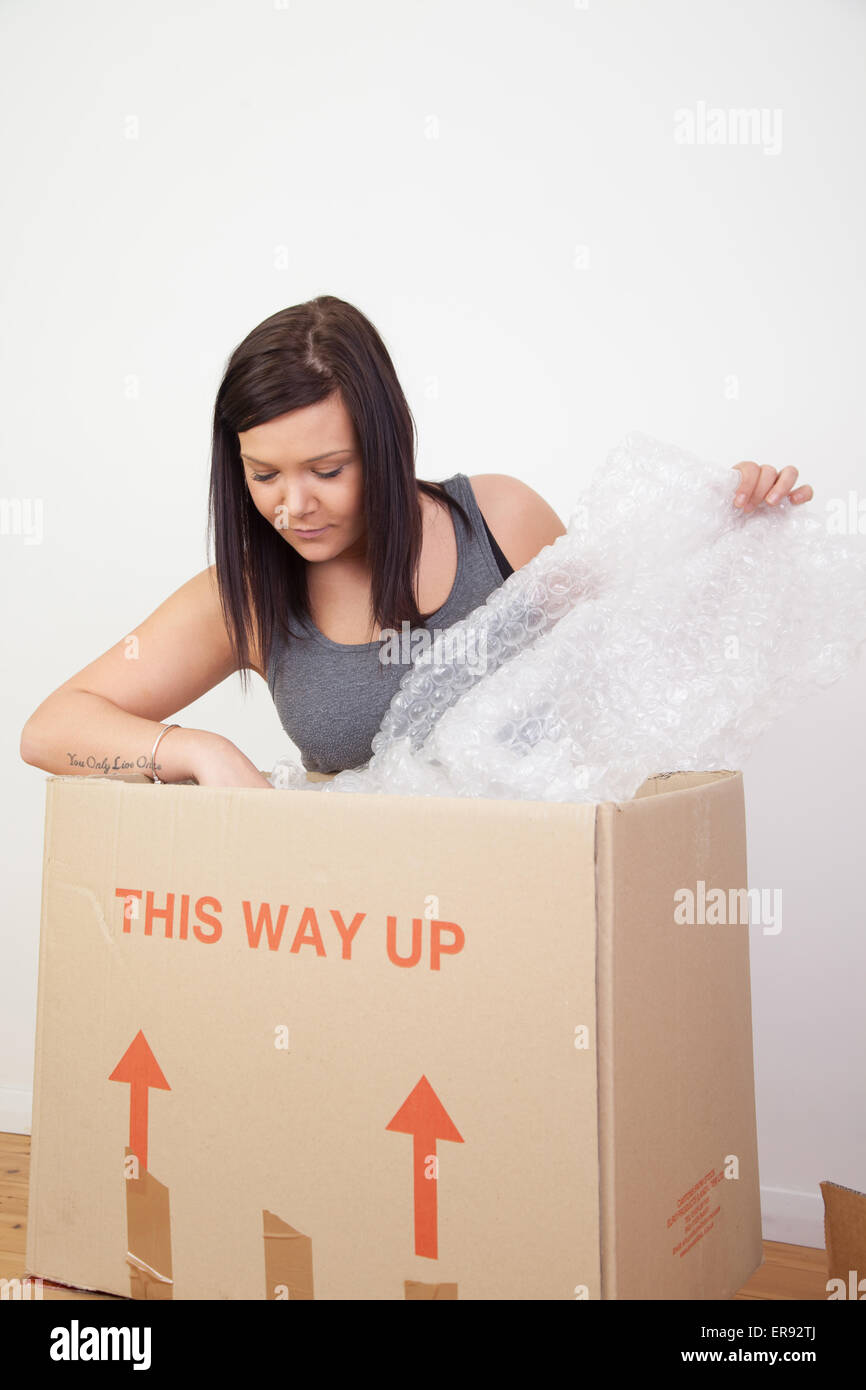 La donna si prepara a pack / disimballare il trasloco. Foto Stock