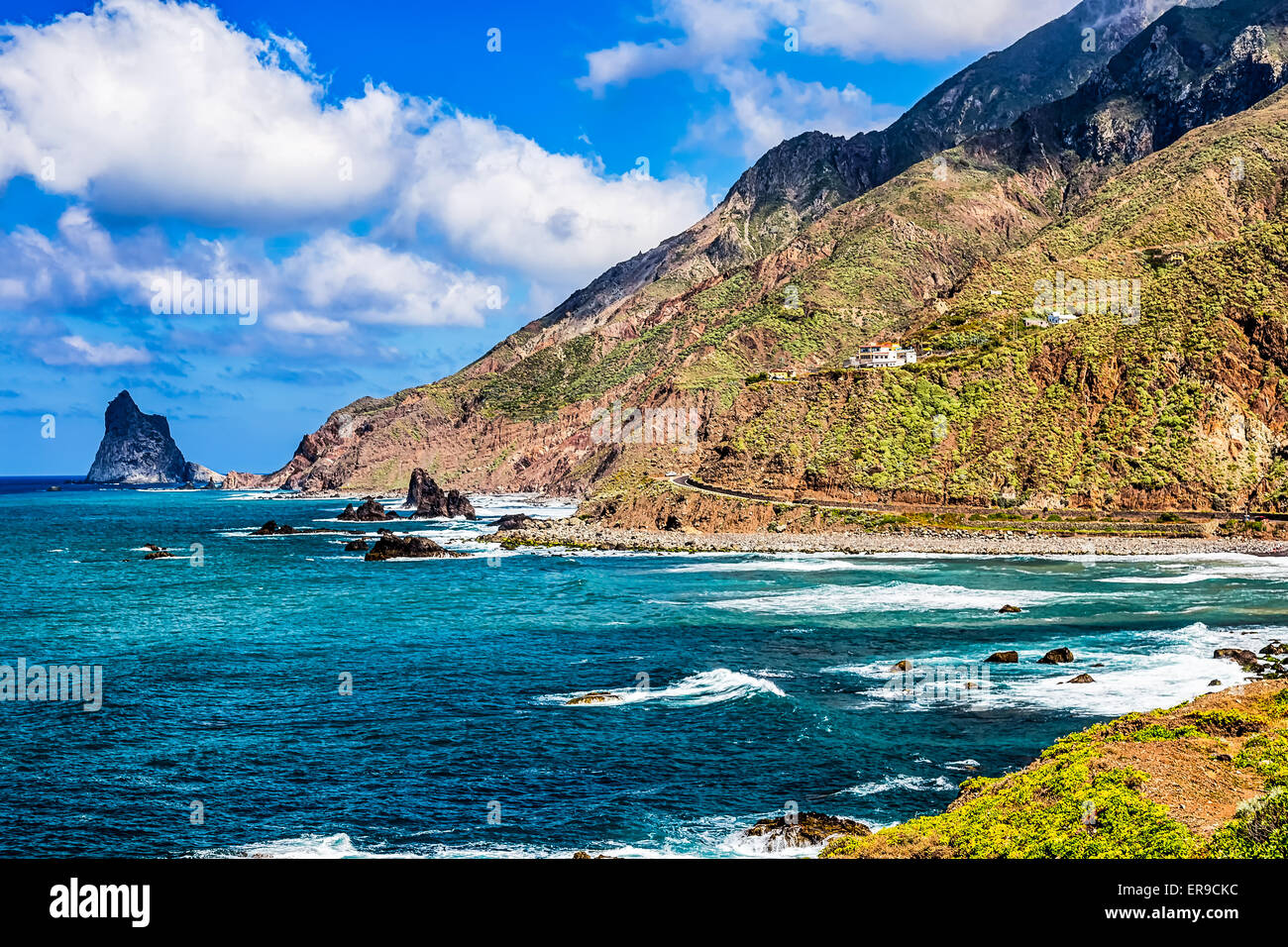 Costa o riva dell Oceano Atlantico con verde di montagna o di roccia e cielo blu con nuvole e la skyline di Tenerife Canary Island Foto Stock
