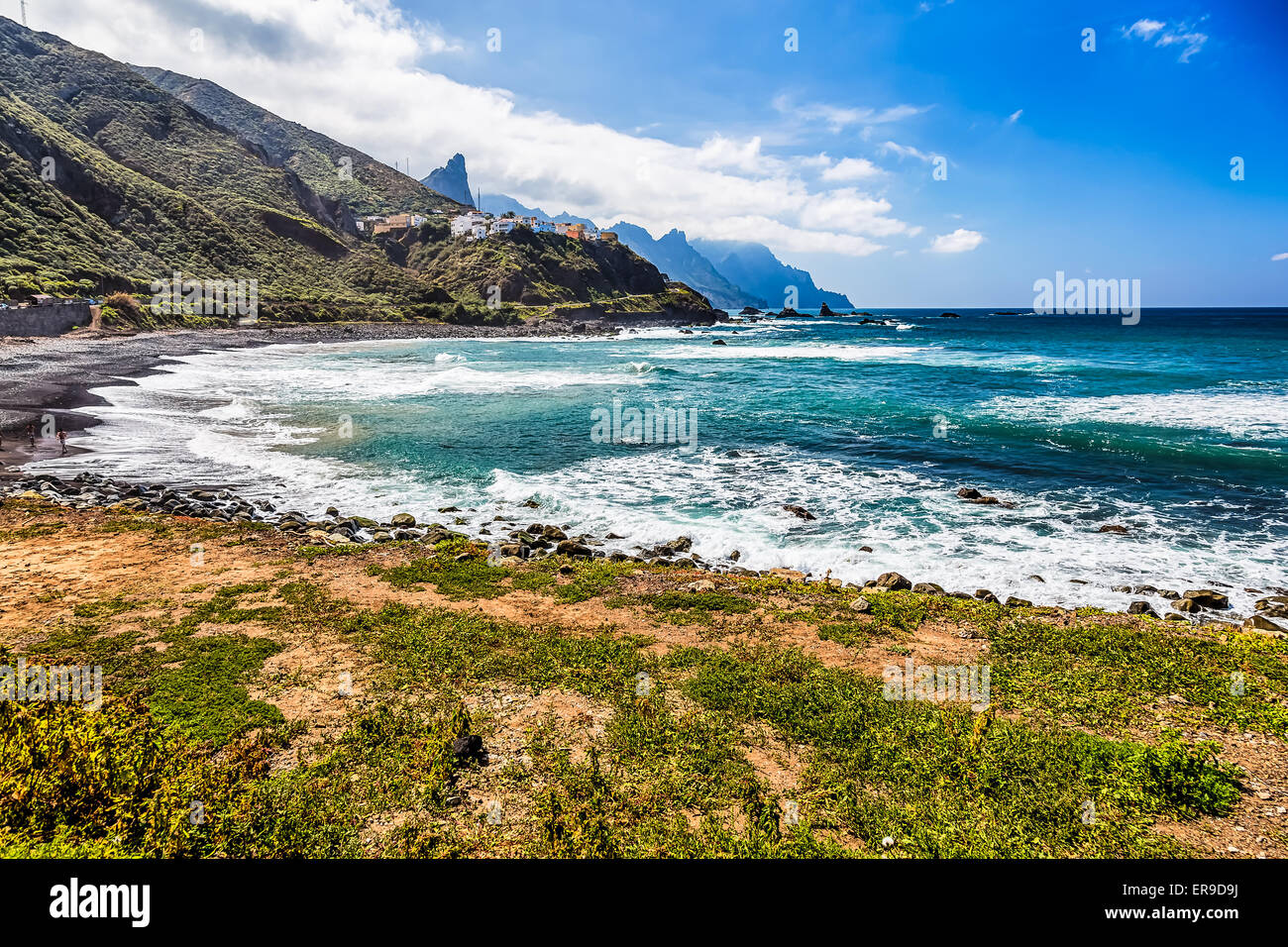 Costa o riva dell Oceano Atlantico con verde di montagna o di roccia e cielo con le nuvole e la skyline o horizon in Tenerife Canarie Foto Stock