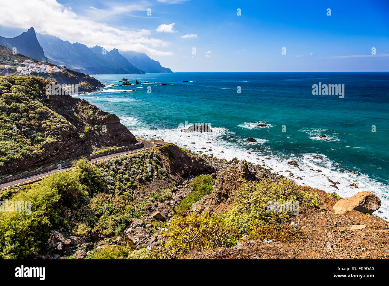 Strada alla costa dell'Oceano Atlantico beach con le montagne o sulle rocce e cielo blu con nuvole e skyline o horizon in Tenerife Canarie Foto Stock