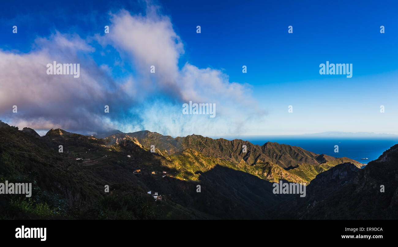 Le nuvole e le montagne o rocce con cielo azzurro sfondo orizzonte vicino all'Oceano Atlantico paesaggio di Tenerife Canary Island Foto Stock