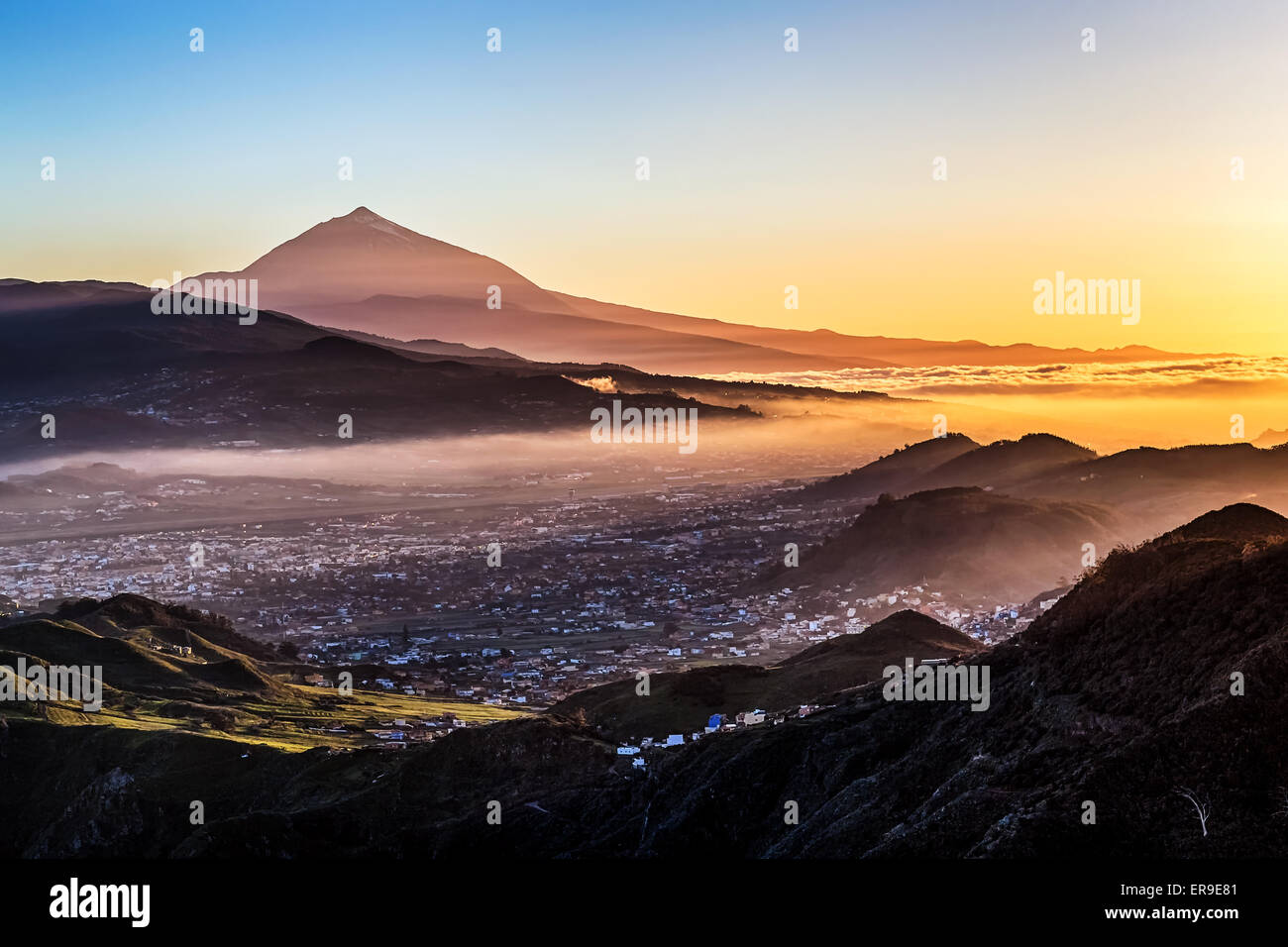 Tramonto a sera nelle montagne e il cielo blu con la nebbia e il vulcano Teide sullo sfondo a Tenerife Isole Canarie, Spagna Foto Stock