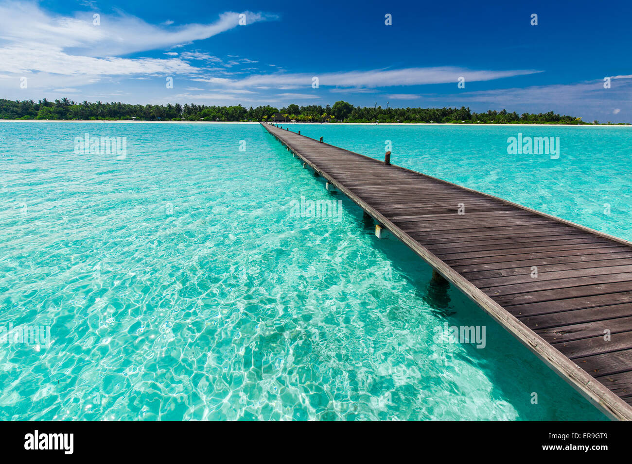 Legno lungo molo su laguna in Maldive con incredibile acqua pulita Foto Stock