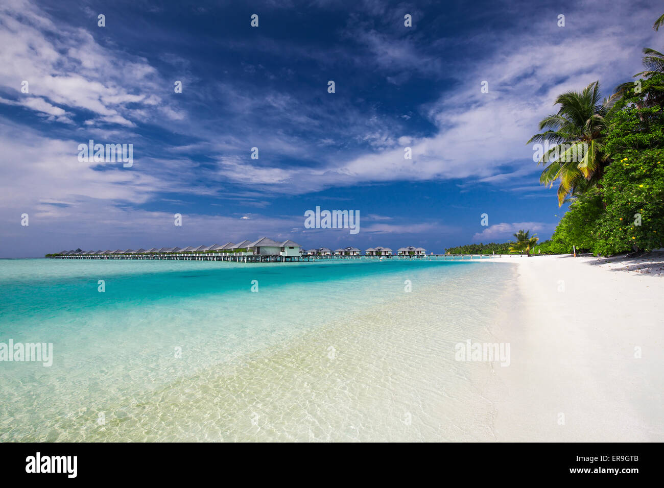 Ville sull'acqua (Bungalows) sulla perfetta isola tropicale delle Maldive con spiaggia pulita Foto Stock