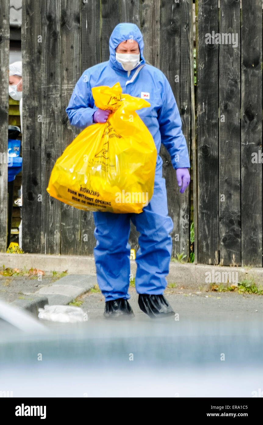 Belfast, Irlanda del Nord. 30 Maggio 2015 - Un forensics officer rimuove le prove in un sacchetto da un assassinio di scena. Credito: Stephen Barnes/Alamy Live News Foto Stock