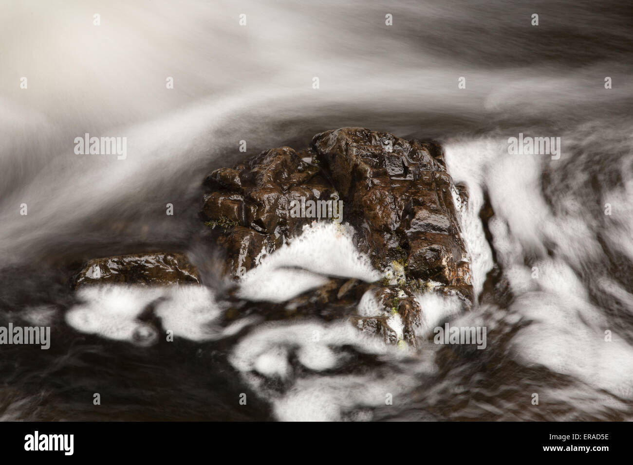 Roccia marrone con turbolento il flusso di acqua. Esposizione a lungo effetto. Foto Stock
