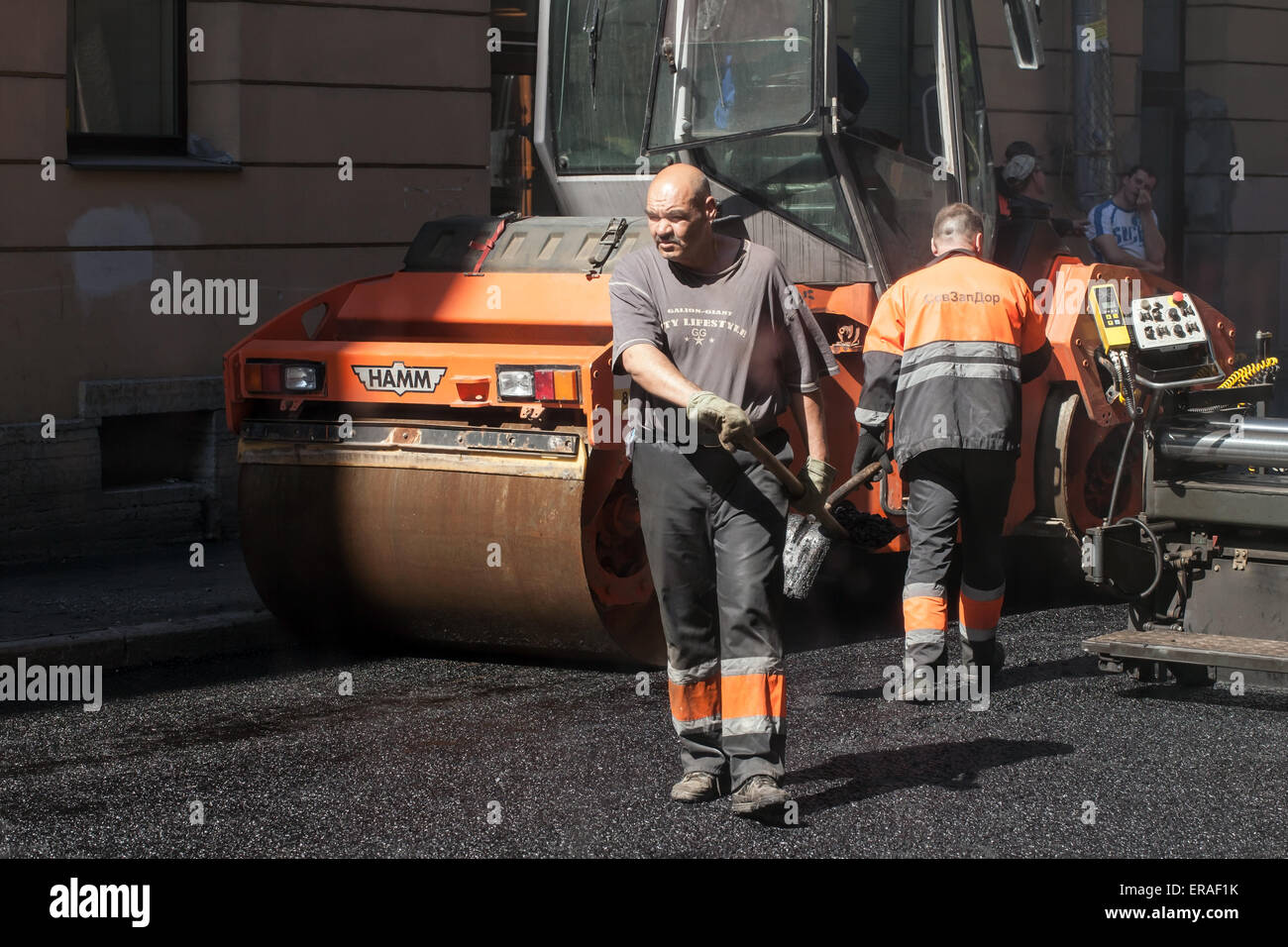San Pietroburgo, Russia - 30 Maggio 2015: uomini al lavoro, strada urbana in costruzione, asfaltatura in corso con i lavoratori, aspha Foto Stock