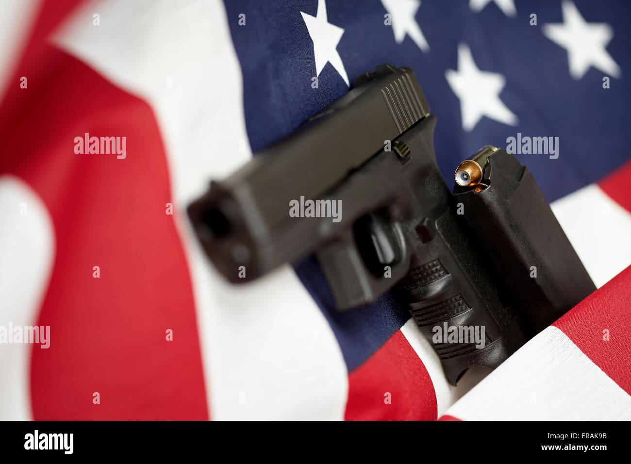 Armati Stati Uniti d'America pistola e bandiera degli Stati Uniti il fuoco selettivo closeup Foto Stock