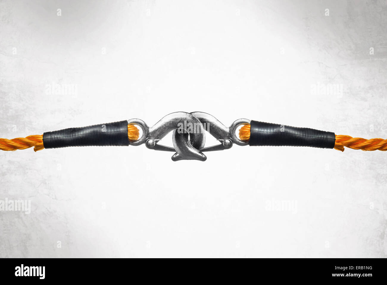 Arancione corde di traino con ganci collegati come immagine concettuale per il legame forte e inscindibile connessione. Foto Stock