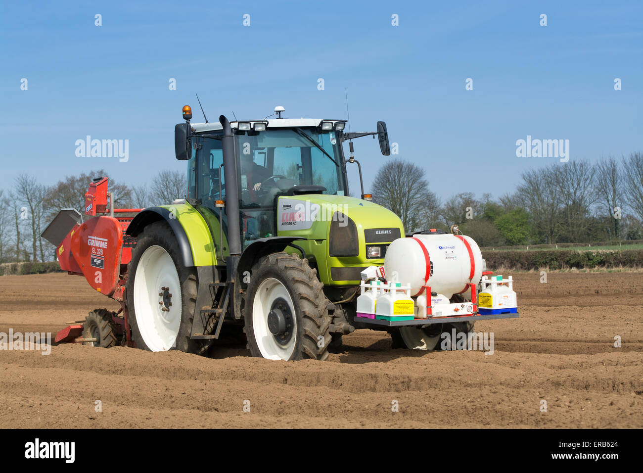 Piantare il seme di patate preparate di fresco letto di seme utilizzando un Grimme seminatrice tirata da una Claas ARES 816RZ trattore, Yorkshire, Regno Unito. Foto Stock