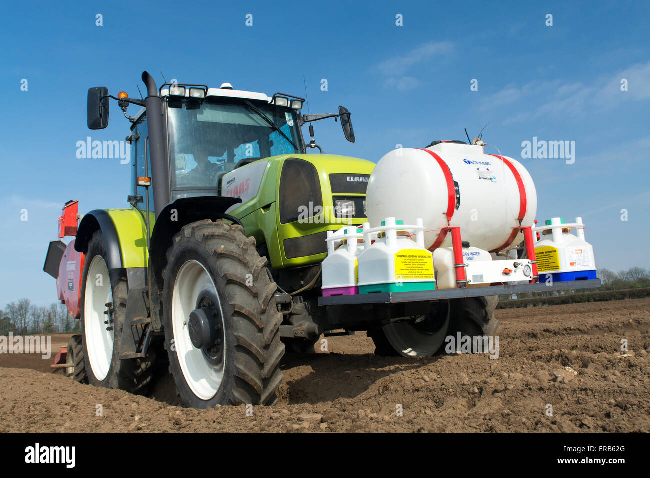 Piantare il seme di patate preparate di fresco letto di seme utilizzando un Grimme seminatrice tirata da una Claas ARES 816RZ trattore, Yorkshire, Regno Unito. Foto Stock