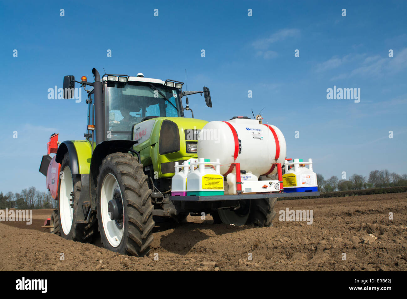 Piantare il seme di patate preparate di fresco letto di seme utilizzando un Grimme seminatrice tirata da una Claas ARES 816RZ trattore, Yorkshire, Regno Unito. Foto Stock