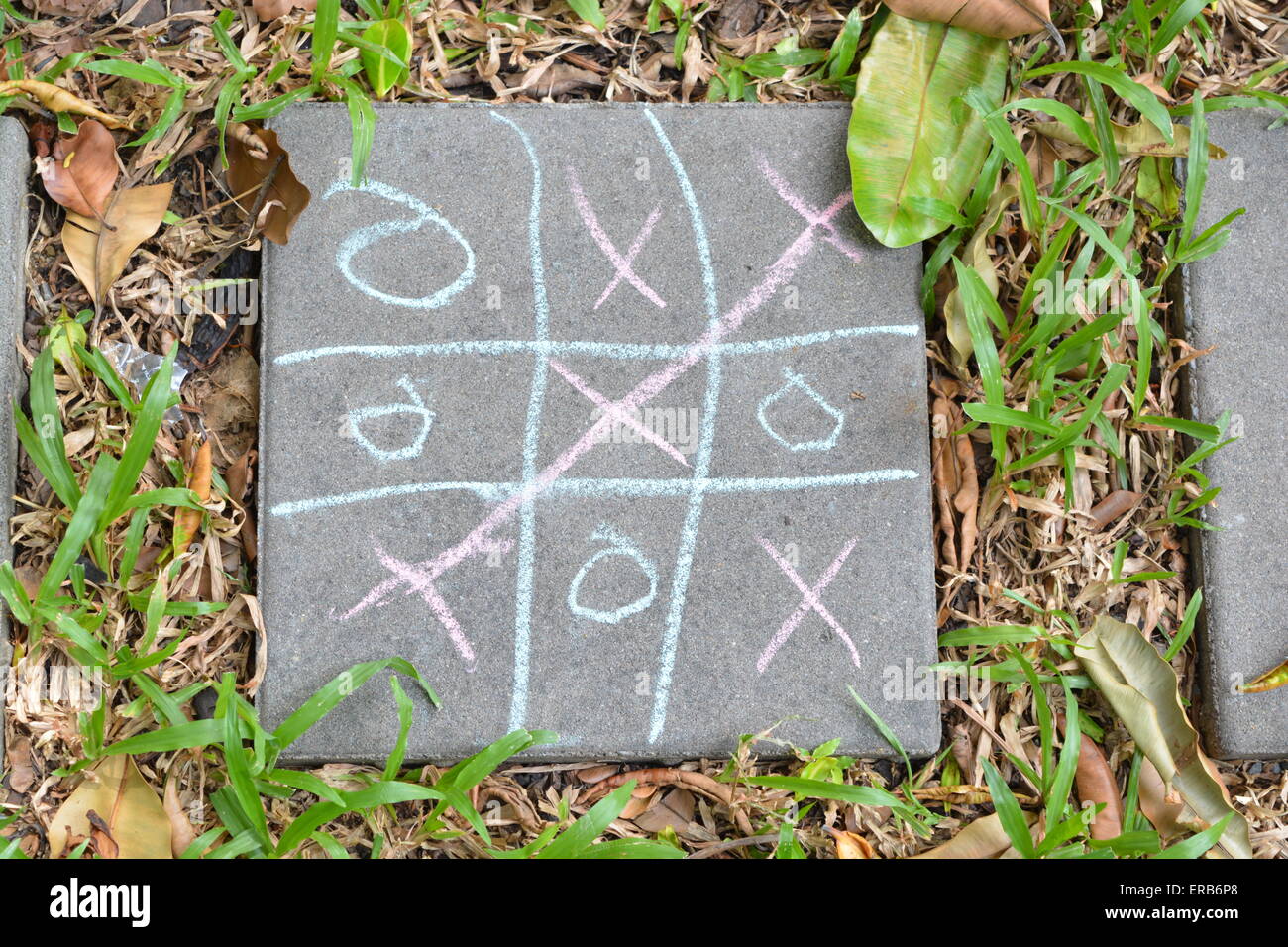 Tic Tac Toe gioco su un giardino piastrellato. Foto Stock