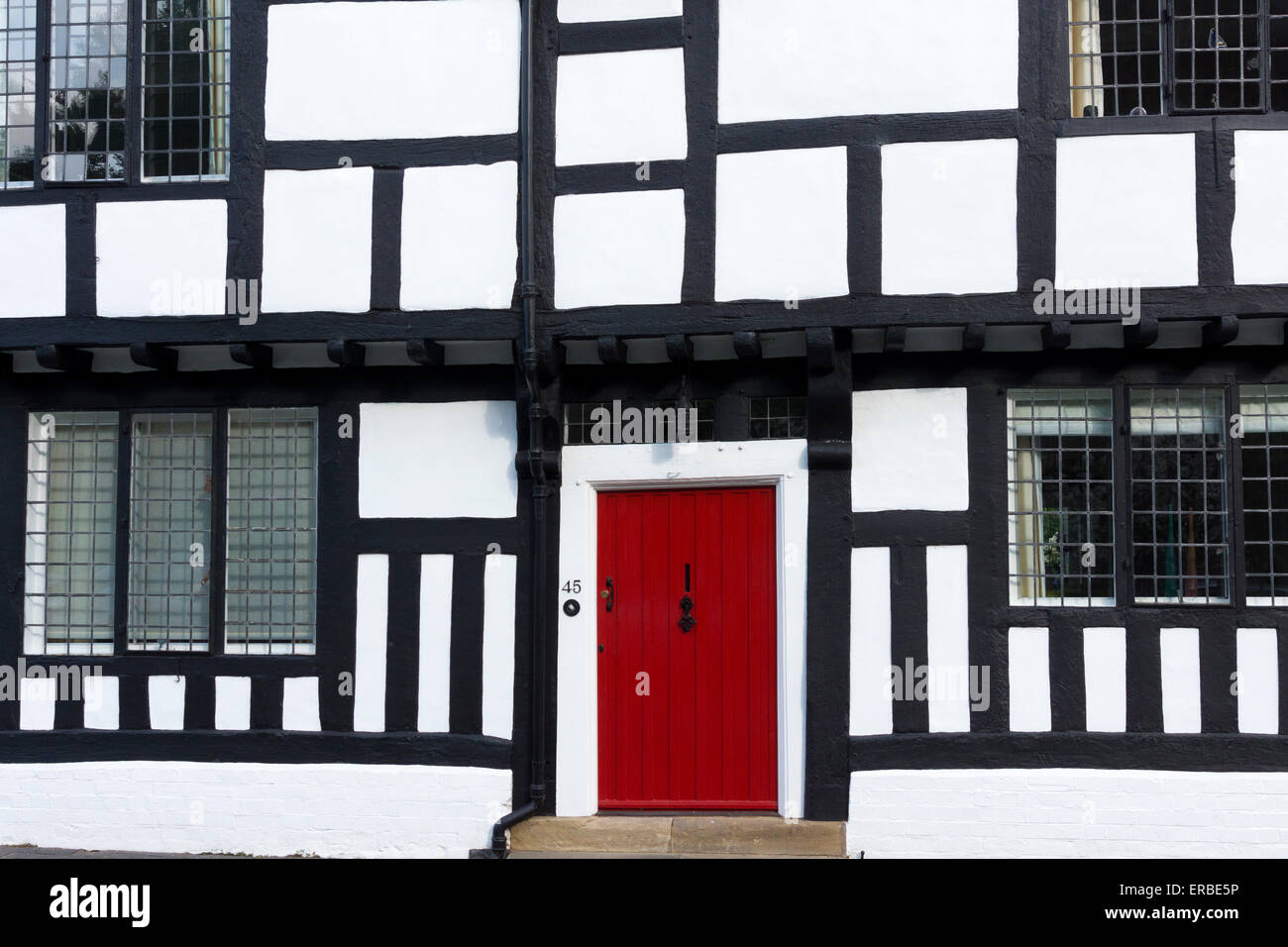 Storica casa con struttura in legno con una porta frontale rossa, Mill Street, Warwick, Warwickshire, Inghilterra Foto Stock