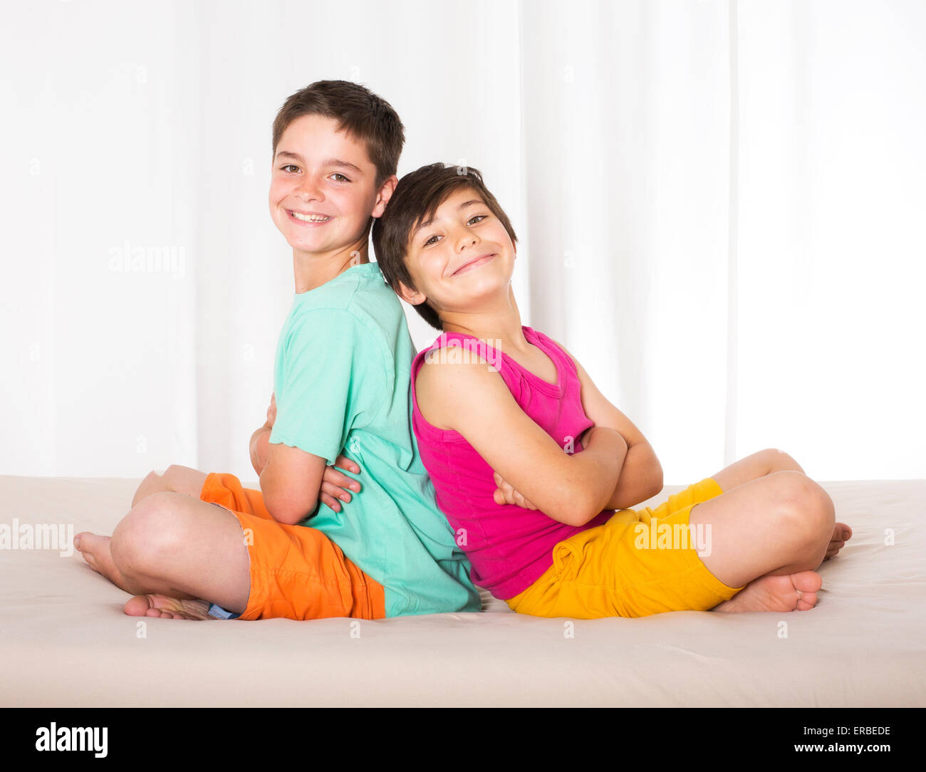 Due ragazzi seduti nel letto e sorridente Foto Stock