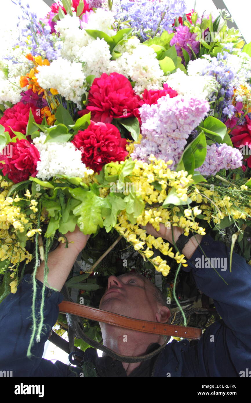 Una ghirlanda maker mette i tocchi di rifinitura per la flora copricapo indossato dal Garland re per celebrare la quercia giorno Apple, Castleton Foto Stock