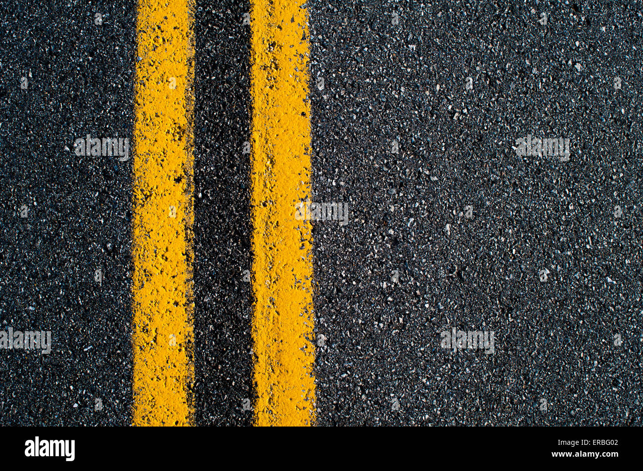 Un doppio giallo "no passando' linea su una strada asfaltata. Foto Stock