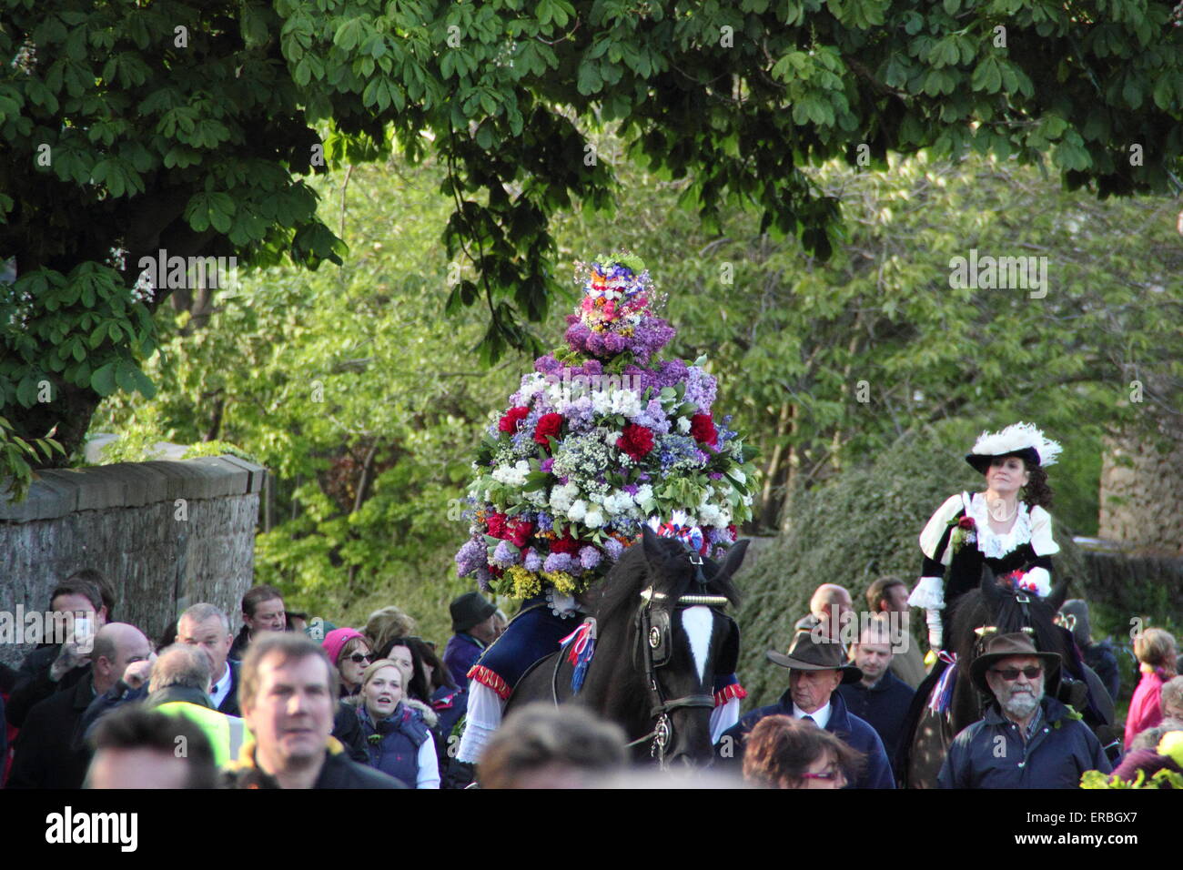 Indossa un copricapo floreale, la ghirlanda re e la sua consorte ride through Castleton per celebrare la quercia giorno Apple, Peak District UK Foto Stock