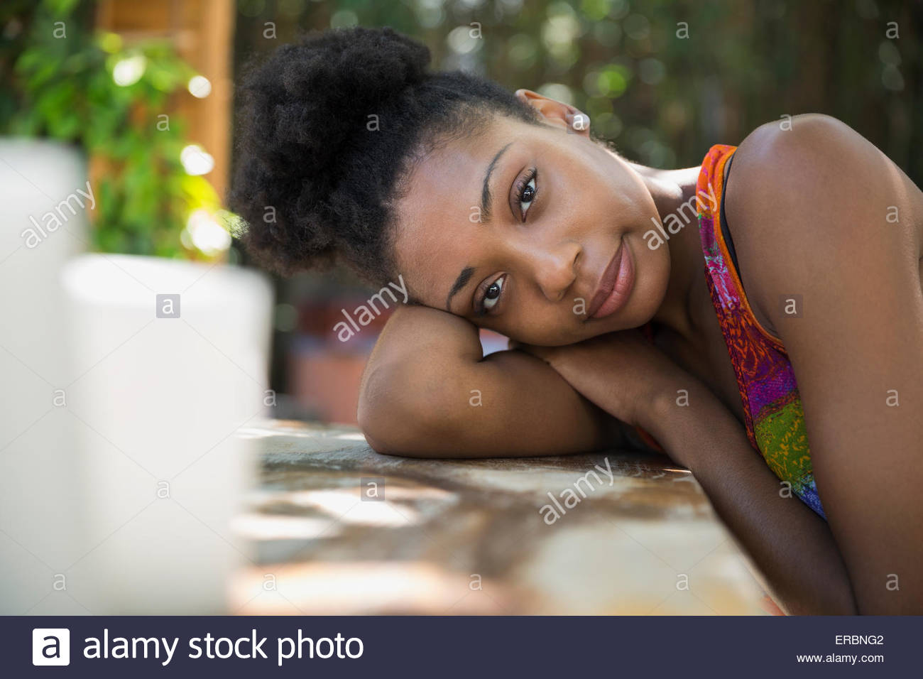 Ritratto donna appoggiata sul tavolo del patio Foto Stock