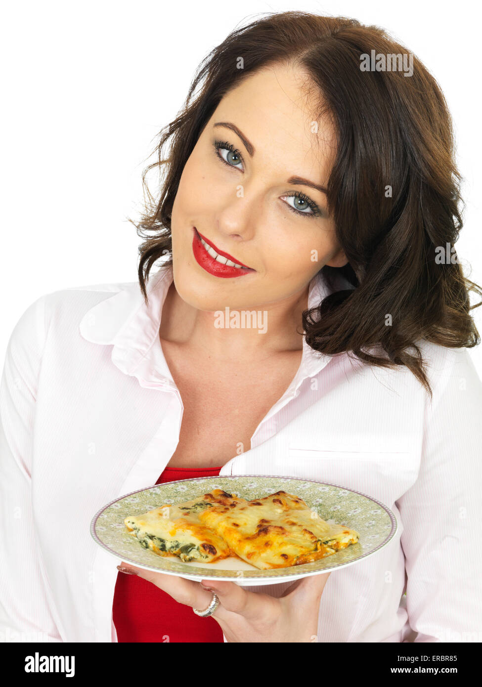 Giovane donna di mangiare un piatto di gustosi piatti italiani autentici Pasta Cannelloni pasto isolata contro uno sfondo bianco con copia di spazio e di un tracciato di ritaglio Foto Stock