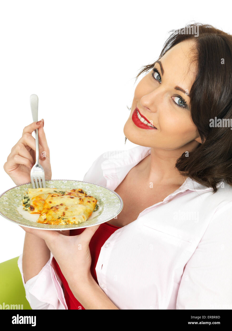 Giovane donna di mangiare un piatto di gustosi piatti italiani autentici Pasta Cannelloni pasto isolata contro uno sfondo bianco con copia di spazio e di un tracciato di ritaglio Foto Stock