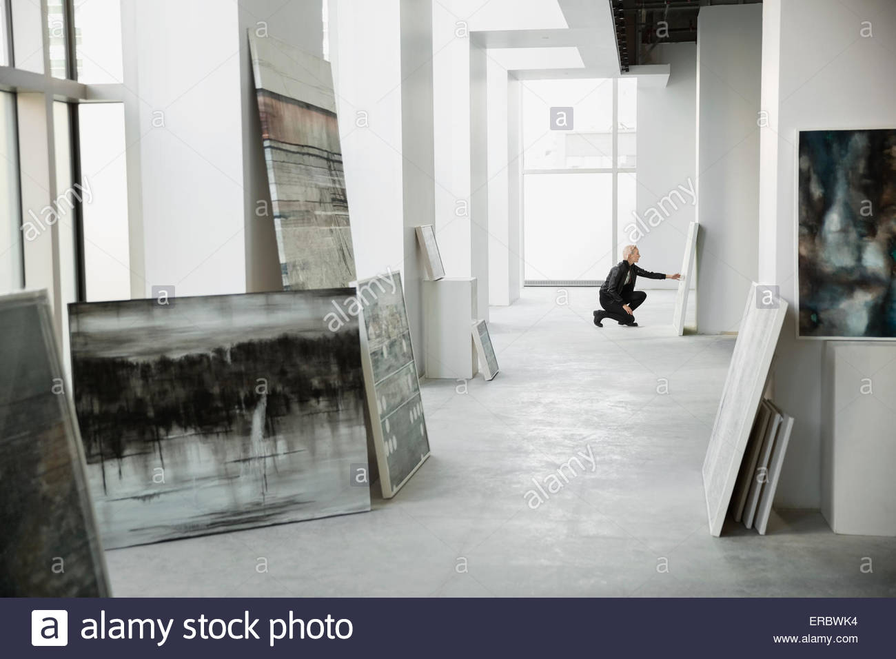 Commerciante di arte esaminando dipinto nella galleria d'arte Foto Stock