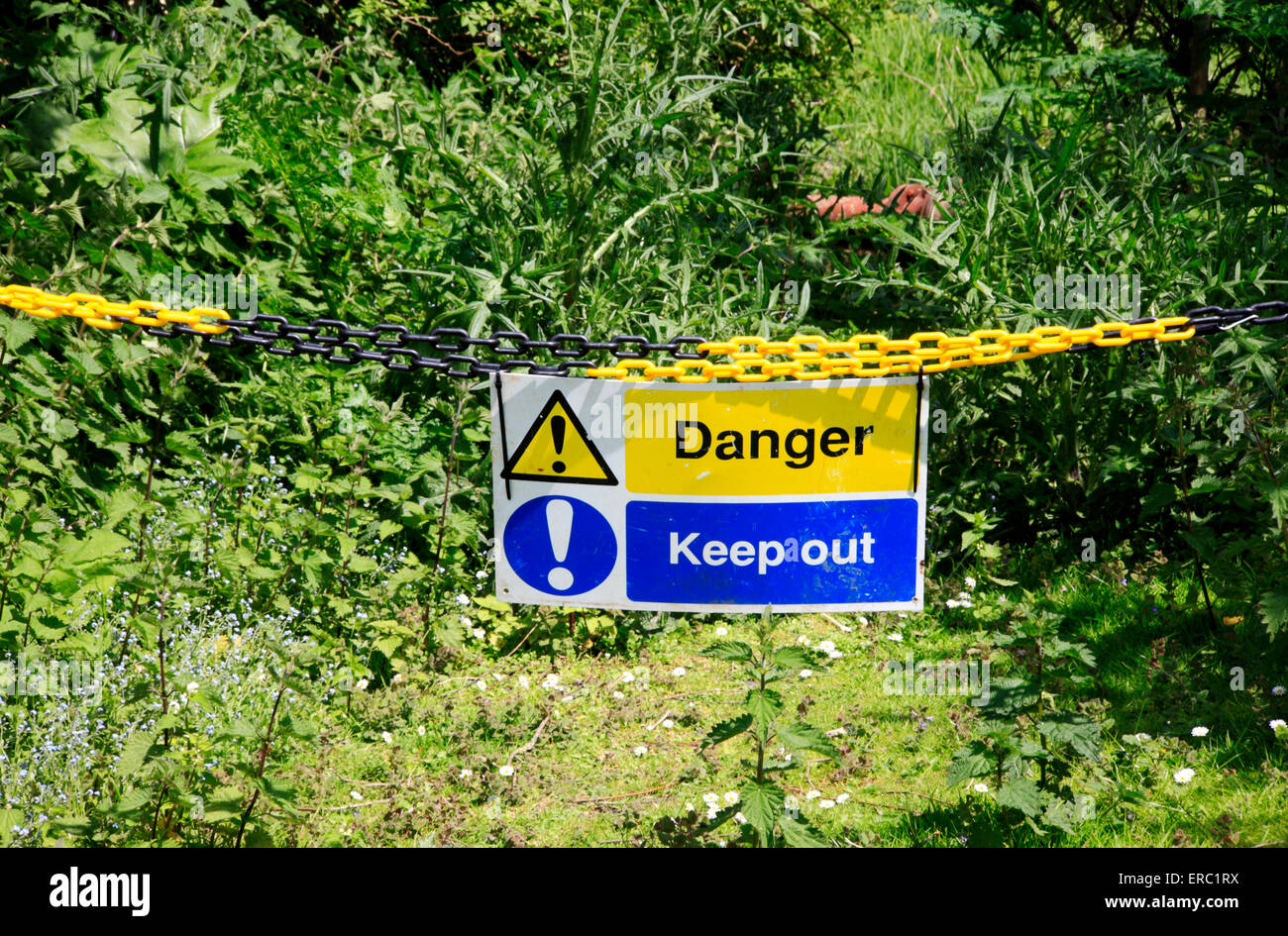 Un pericolo Tenere fuori segno con catena in campagna a Cantley, Norfolk, Inghilterra, Regno Unito. Foto Stock